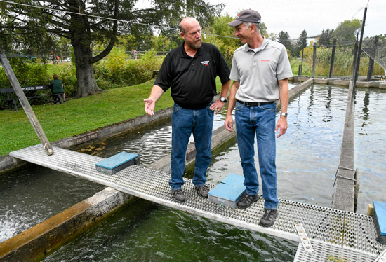 Bill Lansley (left), Onondaga County Parks Commissioner and President of the Onondaga County Federation of Sportsmen’s Clubs, gives Honeywell’s John McAuliffe a tour of the trout ponds at Carpenter’s Brook Fish Hatchery.