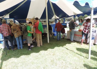 Guests stop by the Honeywell booth to drop off raffle tickets and learn about the habitat restoration achieved as part of the Onondaga Lake cleanup, as well as new recreational and ecological projects underway.