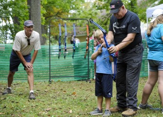 Honeywell Syracuse Remediation Program Manager Steve Miller (left) watches as Robert Murray, of Elbridge, learns how to properly line up, or nock, an arrow on the bow string in the archery area.