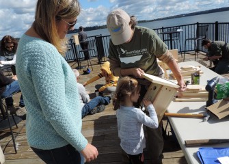 Forty-three volunteers gathered at the Onondaga Lake Visitors Center and along the shoreline to build and install nesting boxes on Saturday, September 29. Eleanor Sunkes, 3, decorates a bird box held by Barbara Kamerance of Central Square as Eleanor’s mom looks on.