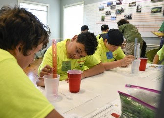 Jack Cofer (left) and Vaughn Spence (center) work on the lake capping engineering exercise as a team at the Onondaga Lake Visitors Center.