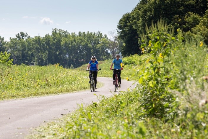 Bikers Joan Schmitkons (left) and Tom Schmitkons (right) ride along the new trail extension near the Harbor Brook area.